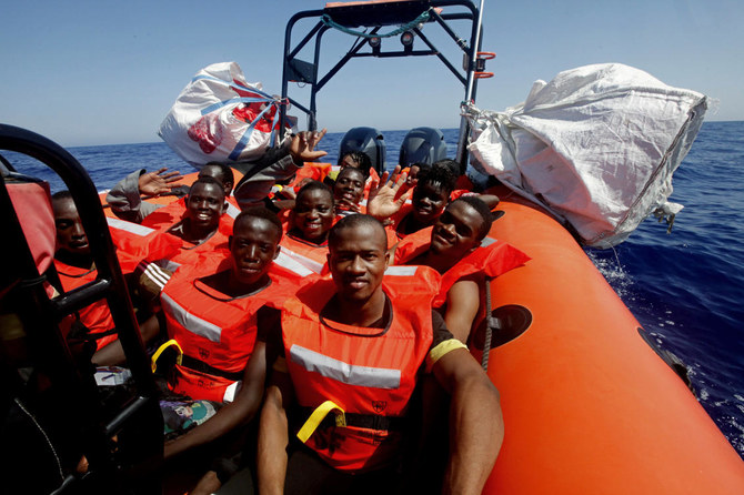 African migrants wave after being rescued by the MV Geo Barents vessel of MSF (Doctors Without Borders), off Libya in the central Mediterranean route on Monday. (AP)