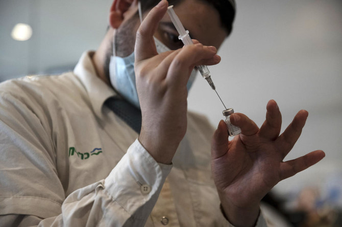 A medical worker prepares a vial of the Pfizer coronavirus vaccine at Clalit Health Service's center in the Cinema City complex in Jerusalem, Wednesday, Sept. 22, 2021.(AP)