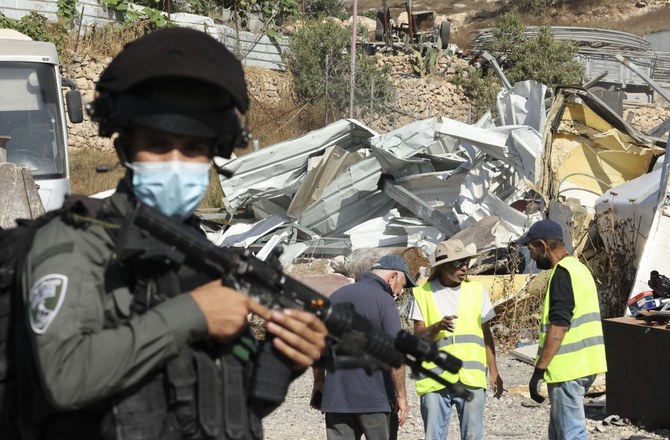 An Israeli bulldozer demolishes a Palestinian metal workshop build in area 