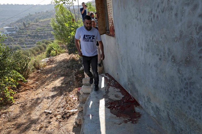 Palestinians gather next to a trail of blood at the site where three Palestinian where killed during clashes with Israeli forces in the village of Beit Anan, in northwest Jerusalem on September 26, 2021. (AFP)