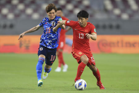 Japan's Kyogo Furuhashi (left) and China's Jingdao Jin fight for possession during a FIFA World Cup qualifying soccer match between China and Japan in Doha, Qatar, Tuesday, Sept. 7, 2021. (AP)