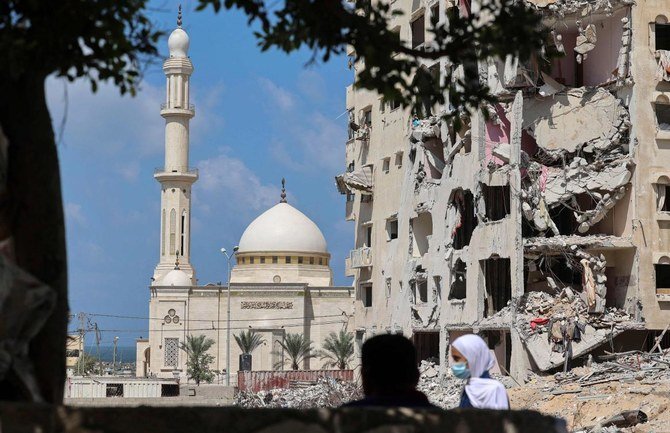 A Palestinian school girl walks past a building that was destroyed during the recent 11-day war between Israel and the Palestinian Hamas movement, in Gaza City, on September 23, 2021. (AFP)