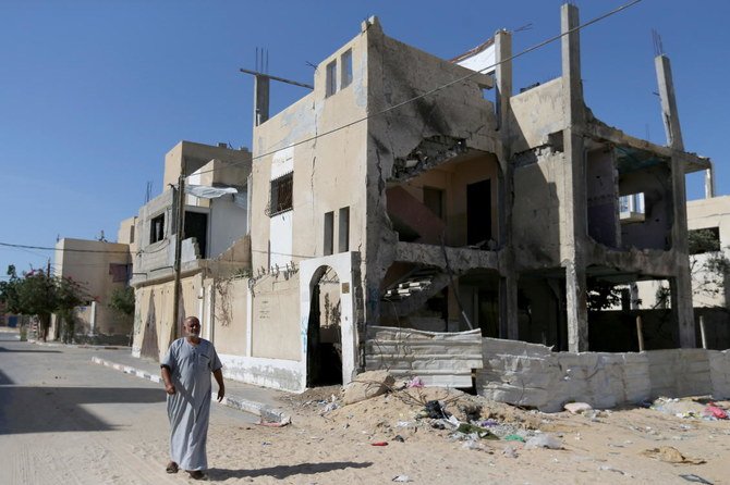 A Palestinian man walks outside a house that was damaged by Israeli strikes during Israel-Hamas fighting last May, in Khan Younis in southern Gaza Strip September 26, 2021. (Reuters)