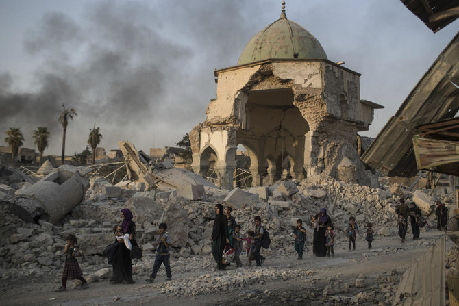 A file photo of fleeing Iraqi civilians walk past the heavily damaged al-Nuri mosque as Iraqi forces continue their advance against Daesh militants in the Old City of Mosul, Iraq (AP)