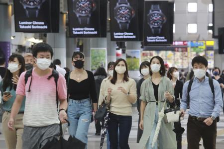 People wearing face masks to help protect against the spread of the coronavirus walk through the train station in Tokyo, Monday, Sept. 6, 2021. (AP)
