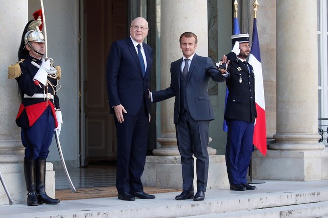 French President Emmanuel Macron (right) welcomes Lebanese Prime Minister Najib Mikati prior to their meeting at the Elysee Palace, in Paris, Friday, Sept. 24, 2021. (AP)