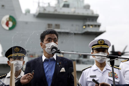 Japan Defense Minister Nobuo Kishi speaks to the members of the media after he inspected the British Royal Navy's HMS Queen Elizabeth aircraft carrier (behind) at the US naval base in Yokosuka, Kanagawa Prefecture, Japan, Monday, Sept. 6, 2021. (AP)