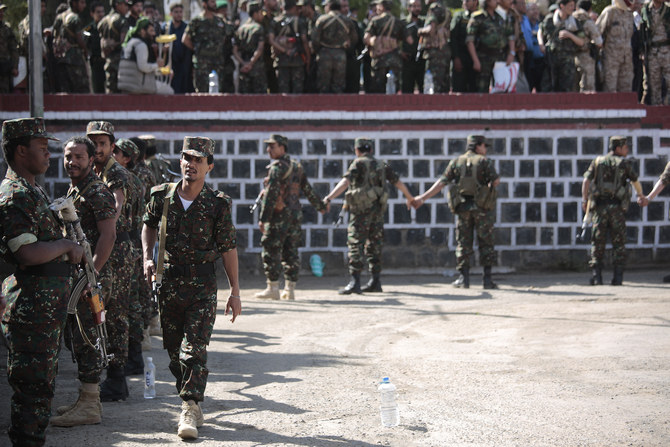 Houthi fighters stand guard during the execution of nine men, convicted of involvement in the killing of senior Houthi official Saleh al-Samad in Sanaa. (AP)