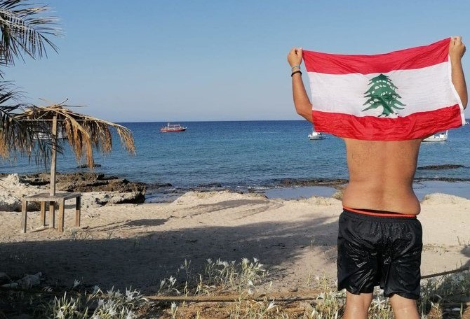 Kabbara raises the Lebanese flag after swimming 5.5km to Rabbit’s Island off the coast of Lebanese northern city of Tripoli. (Supplied/Yahya Nabil Kabbara)