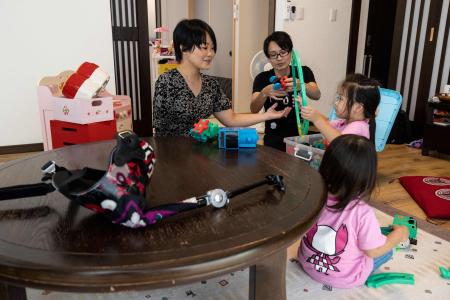 In this photo taken on August 28, 2021, Japanese violinist Manami Ito (2nd L) interacts with her daughters Miu and Mei (L and 2nd R), and husband Yuki. (AFP)