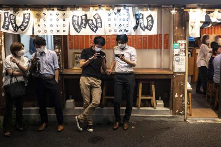Evening diners wait for vacant seats at a restaurant in Tokyo on September 24, 2021. (AFP)
