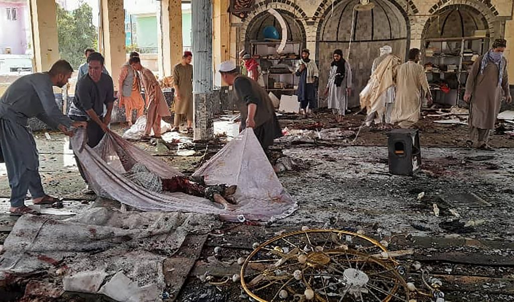 Afghan men prepare to carry the dead body of a victim inside a Shiite mosque after a bomb attack in Kunduz province on October 8, 2021. (AFP)