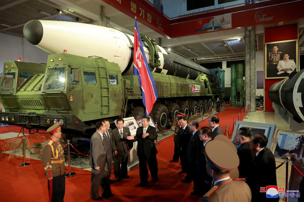 This picture taken on October 11, 2021 and released from North Korea's official Korean Central News Agency (KCNA) on October 12 shows North Korean leader Kim Jong Un (C) speaks in front of an intercontinental ballistic missile (ICBM) displayed during the defence development exhibition 
