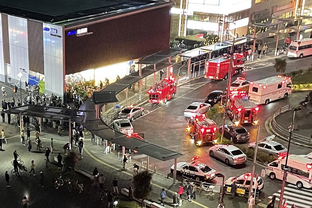 This aerial image shows firefighters and rescue workers gathered outside Kokuryo Station on the Keio Line in the city of Chofu in western Tokyo on October 31, 2021, after a man injured at least 10 people in a knife and fire attack on a train. (AFP)