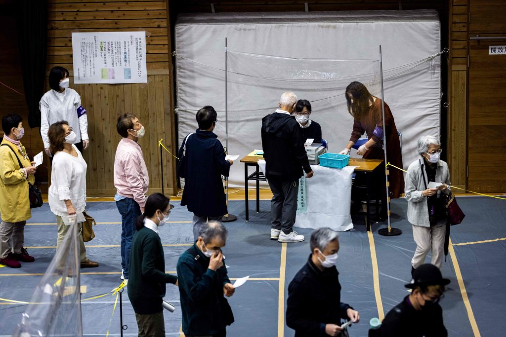 Voters queue to cast their ballots for Japan's general election at a polling station in Tokyo on Oct. 31, 2021. (File photo/AFP)