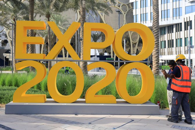 Workers are pictured next to the Expo 2020 logo ahead of the opening ceremony in Dubai on Sept. 30, 2021. (REUTERS/Rula Rouhana)