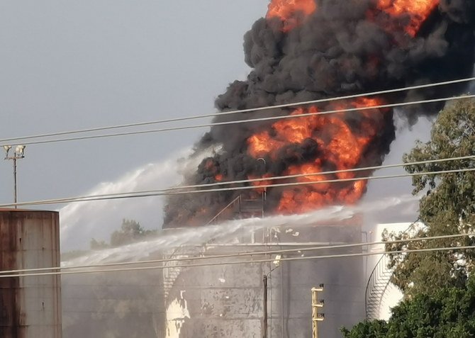 Water is sprayed on a fire at the Zahrani oil facility in southern Lebanon on Oct. 11, 2021. (Reuters)