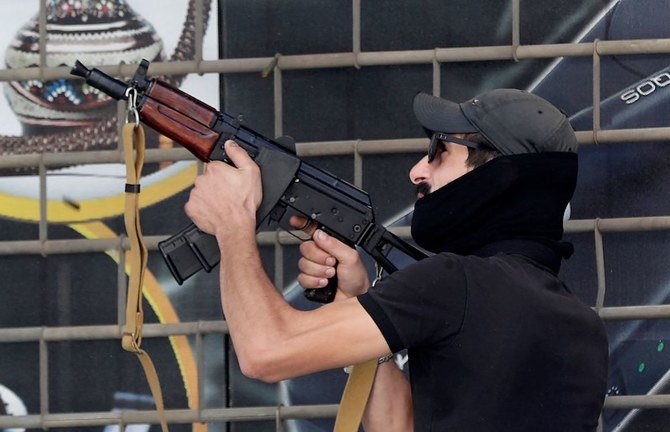 An army soldier carries a schoolchild as civilians flee after gunfire erupted erupted in Beirut. (Reuters)