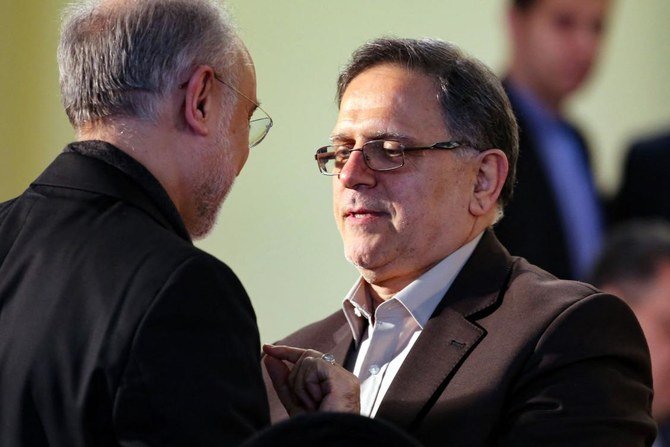 In this file photo taken on January 17, 2016, then head of the Central Bank of Iran, Valiollah Seif (R), speaks to Iran's head of Atomic Energy Organisation(IAEO) Ali Akbar Salehi. (File/AFP)