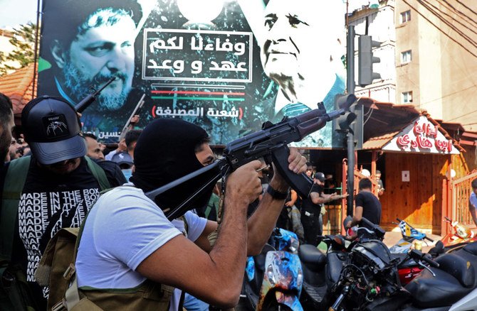 A Hezbollah fighter fires his gun during the funeral on October 15, 2021 of members who were killed during clashes in Beirut's southern suburbs a day earlier. (IBRAHIM AMRO / AFP)