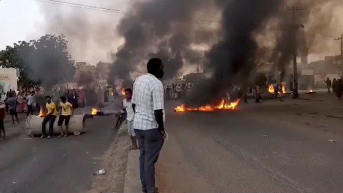 People gather around as smoke and fire are seen on the streets of Kartoum, Sudan amid reports of a coup on Oct. 25, 2021 in this still image from video obtained via social media. (RASD Sudan Network via Reuters)