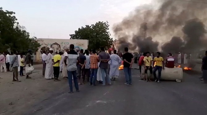 People gather around as smoke and fire are seen on the streets of Kartoum, Sudan amid reports of a coup on Oct. 25, 2021 in this still image from video obtained via social media. (RASD Sudan Network via Reuters)