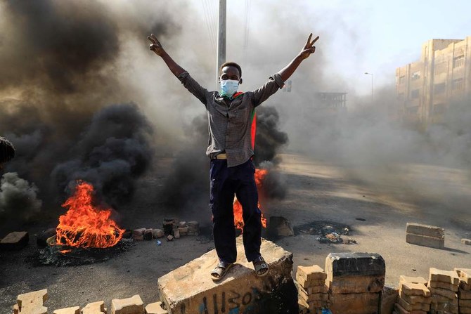 Sudanese protesters burn tires to block a road in Khartoum amid reports of a military coup. (AFP)