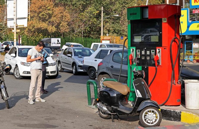 Cars and motorbikes queue to fill up at a service station in Tehran on Oct. 26, 2021 amid a nationwide disruption of the petrol distribution system. (AFP)