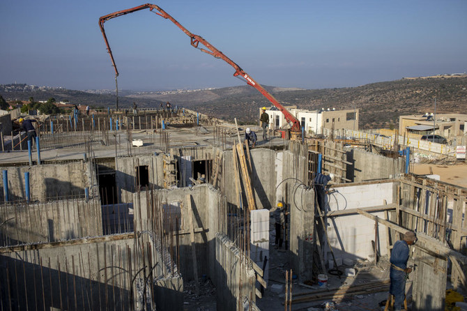 Palestinian laborers work building new houses in the West Bank Jewish settlement of Bruchin near the Palestinian town of Nablus, Monday, Oct. 25, 2021. (AP)