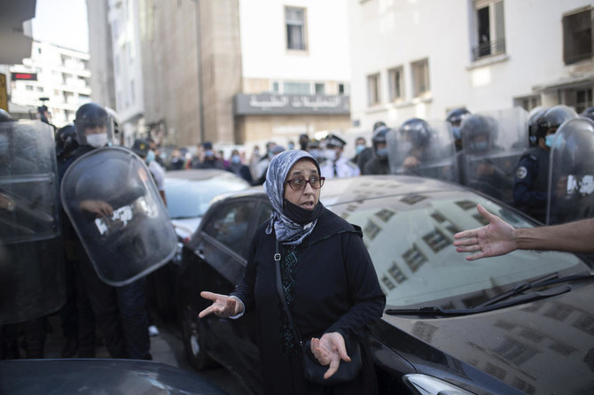 A protester gestures as security forces disperse a protest against the government enforcing of a mandatory COVID-19 vaccine pass to access public places and travel in Rabat on Wednesday. (AP)