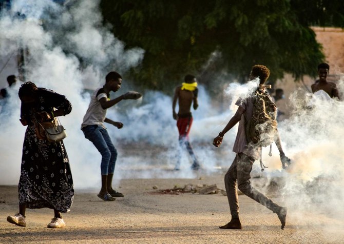 Sudanese youths confront security forces amidst tear gas fired by them to disperse protesters in Khartoum on Oct. 27, 2021. (AFP)