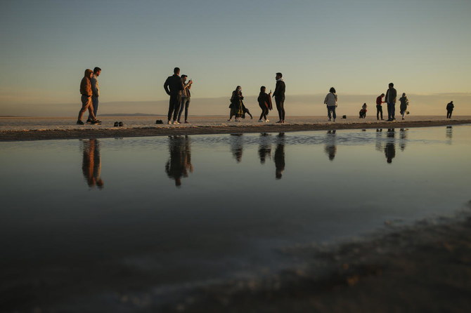 People take photograph and stroll at Tuz lake in Ankara province of Turkey, Tuesday, Oct. 26, 2021. (AP Photo/Emrah Gurel)