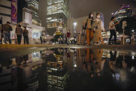 People wearing protective masks walk around the famed Shibuya scramble crossing in a shopping and entertainment district on Wednesday, in Tokyo. (AP)