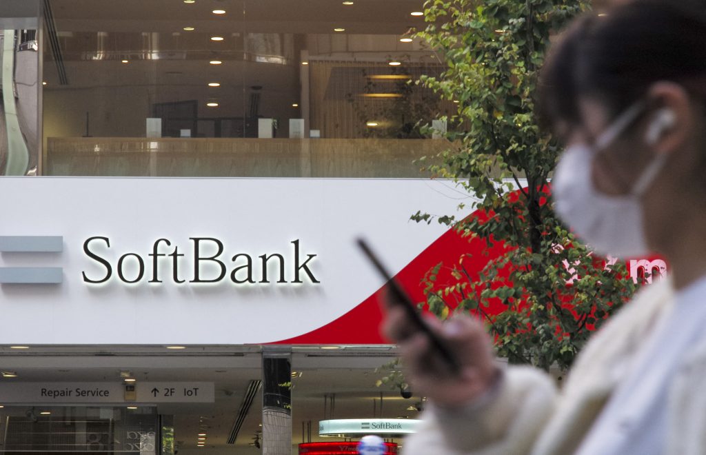 A woman walks past a SoftBank mobile shop in Tokyo on November 8, 2021. (AFP)