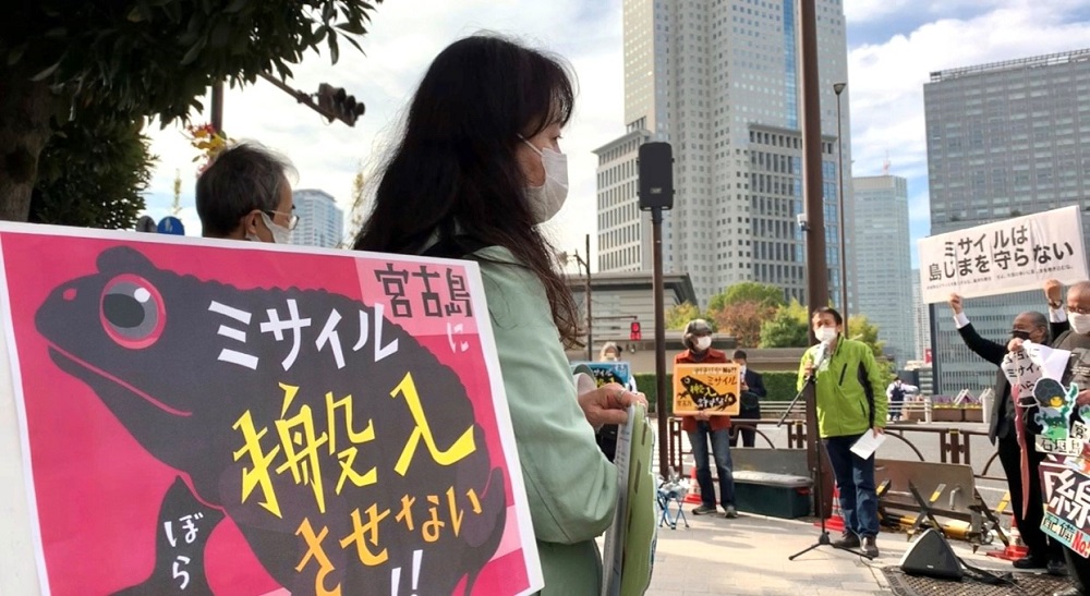 A protestor carries a signboard saying (Don’t bring missiles to Miyakojima) addressed to the Japanese government. (ANJ/ Pierre Boutier)