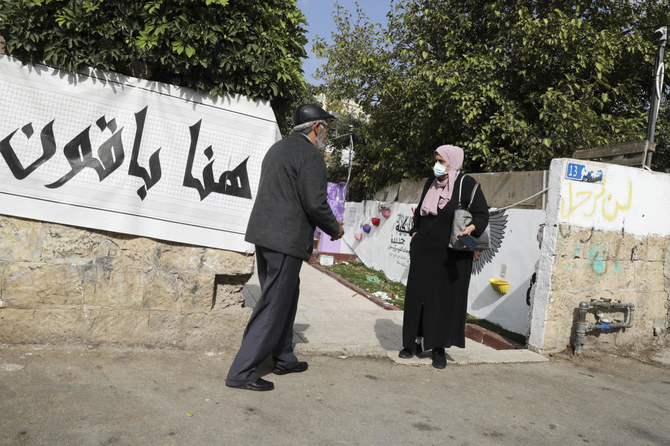 Palestinian residents talk on the sidewalk of Sheikh Jarrah neighborhood of east Jerusalem, where families are under threat of forced displacement from their homes by Jewish settlers, on Tuesday. (AP)