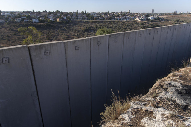 A section of Israel's separation barrier separates the Israeli settlement of Hashmona'im, left and the Palestinian West Bank villages of al-Medya and Nilin, west of Ramallah, Sunday, Nov. 7, 2021. (AP Photo/Nasser Nasser)