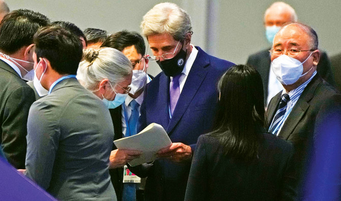 China’s chief negotiator Xie Zhenhua, right, looks on as John Kerry, US special presidential envoy for climate, looks at his papers during a stocktaking plenary session at the COP26 in Glasgow, Scotland on Saturday. (AP)