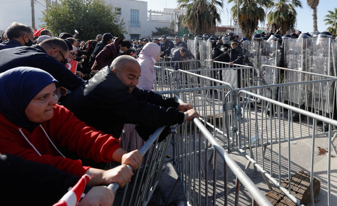 Demonstrators try to remove the barricades during a protest against Tunisian President Kais Saied's seizure of governing powers, in front of the parliament, in Tunis, Tunisia, November 14, 2021. (Reuters)