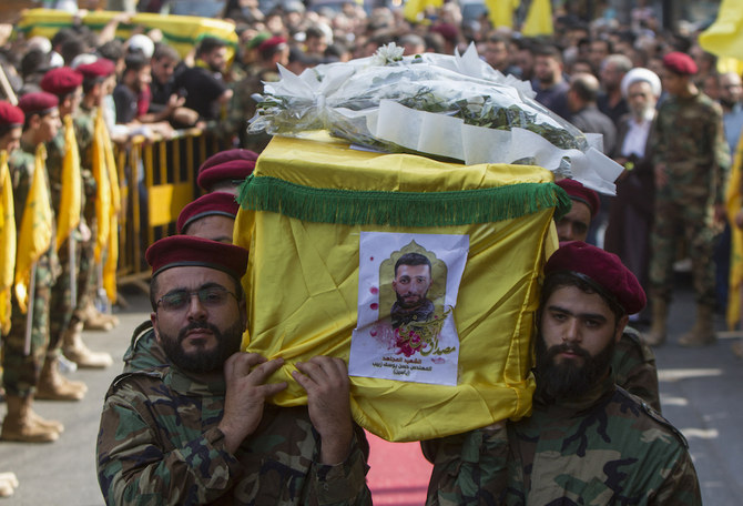 Hezbollah fighters brandish weapons at the funeral procession (above) of a slain comrade, with experts predicting that the group will resist calls to disarm. (AFP/File Photo)