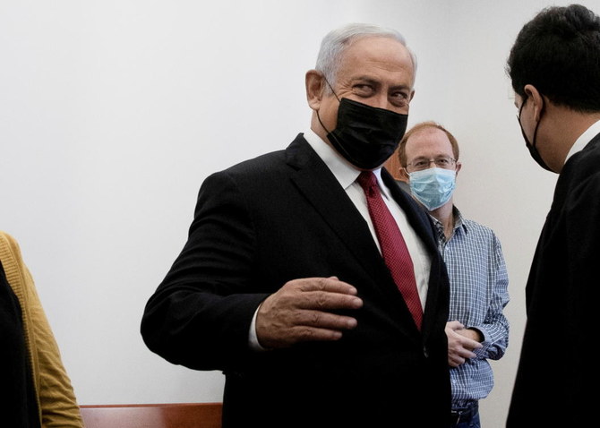 Benjamin Netanyahu is surrounded by journalists and lawyers in a courtroom before testimony by star witness Nir Hefetz, a former aide, in Netanyahu's corruption trial at the District Court in east Jerusalem, November 22, 2021. (Reuters)