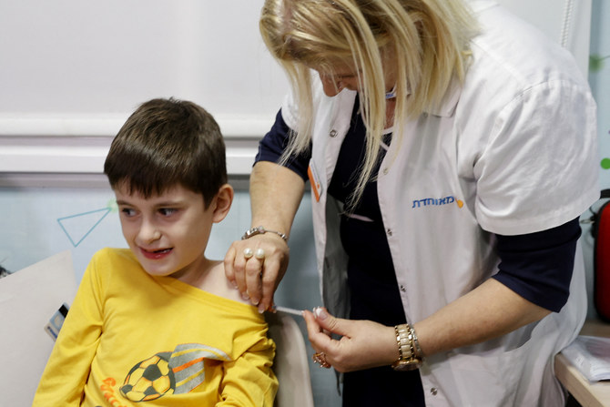 Israeli boy Yoav, 9, receives a dose of the Pfizer/BioNTech Covid-19 vaccine at the Meuhedet Healthcare Services Organization in Tel Aviv on November 22, 2021. (AFP)