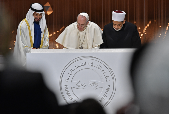 Abu Dhabi’s Crown Prince Mohammed bin Zayed al-Nahyan (L) watches as Pope Francis (C) and Egypt’s Azhar Grand Imam Sheikh Ahmed Al-Tayeb sign documents during the Human Fraternity Meeting in 2019. (AFP/File Photo)