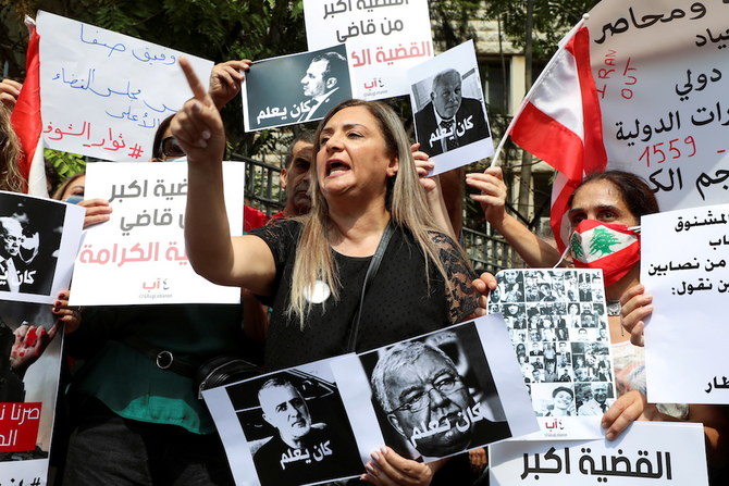 Demonstrators carry banners and flags during a protest in front of the Justice Palace after a probe into Beirut blast was frozen, in Beirut. (Reuters)