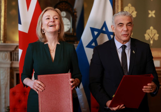 Britain’s Foreign Secretary Liz Truss and Israeli Foreign Minister Yair Lapid react after signing a memorandum of understanding at Britain’s Foreign Commonwealth & Development Office in London on Monday. (Reuters)