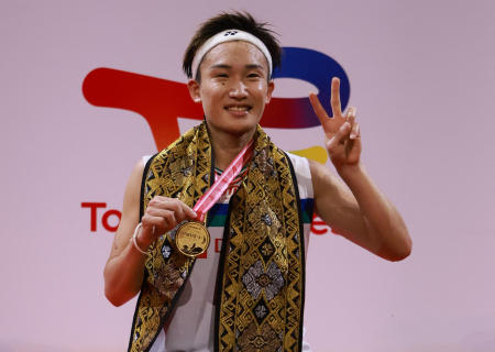 This handout photo taken and released on November 21, 2021 by the Badminton Association of Indonesia shows Japan’s Kento Momota celebrating on the winner's podium during the awards ceremony. (AFP)