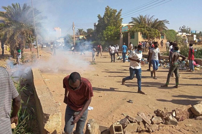 Sudanese anti-coup protesters run for cover from tear gas fired by security forces amid ongoing protests against last month’s widely condemned military takeover, in Umdurman on Wednesday. (AFP)