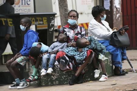 A mother takes time to rest with her children in Harare, Zimbabwe, Friday, Nov, 26, 2021. A slew of nations have moved to stop air travel from southern Africa, and stocks have plunged in Asia and Europe in reaction to news of a new, potentially more transmissible COVID-19 variant. (AP)