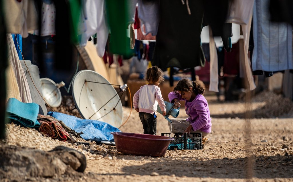 Syrian children, displaced from Ras al-Ain, a border town controlled by Turkey and its Syrian proxies, are surrounded with laundry hung to dry between tents in the camp of Washukanni in the northeastern Syrian al-Hasakeh governorate. (AFP)