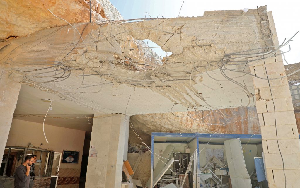 A man stands amid the debris at the entrance of a field hospital in the the village of Atareb in the northern Syrian province of Aleppo, after it was reportedly targeted by regime shelling, March. 21, 2021.